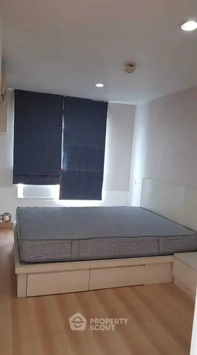 Cozy bedroom with modern design and ample natural light, featuring a comfortable bed and stylish blinds.