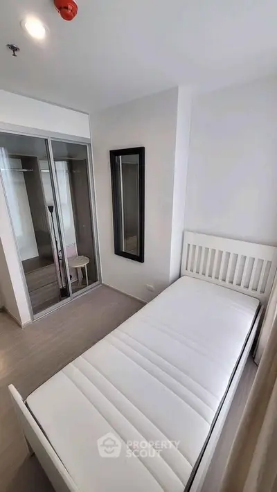 Modern minimalist bedroom with single bed and mirrored closet