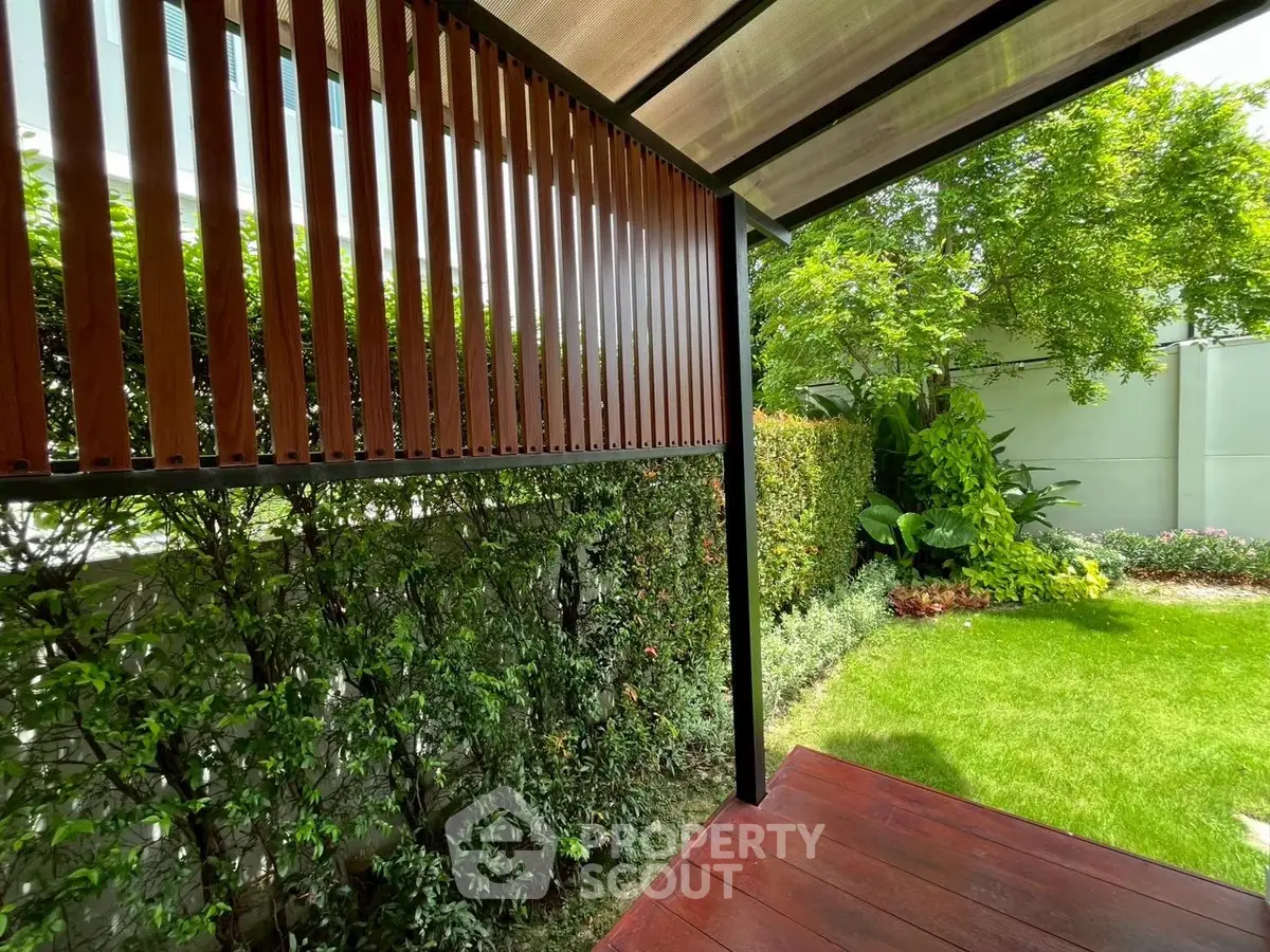 Charming garden view with lush greenery and wooden deck, perfect for outdoor relaxation.