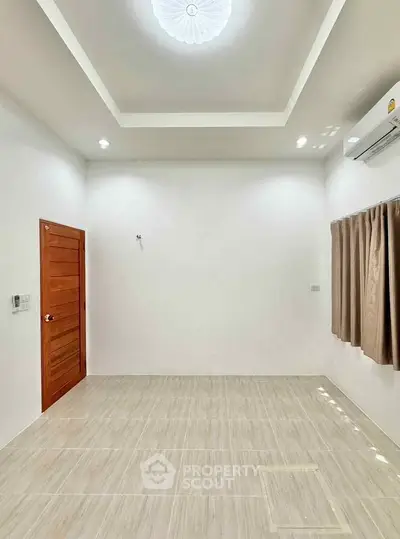 Spacious empty room with modern ceiling and air conditioning, ready for customization.