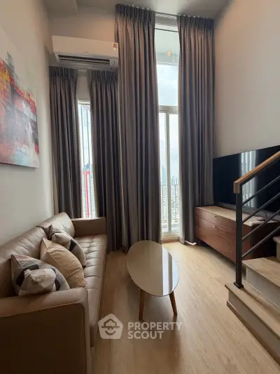 Modern living room with high ceiling and large windows offering city views, featuring a cozy sofa and stylish decor.