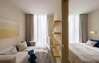 Modern studio apartment with cozy living area and stylish bedroom, featuring elegant decor and natural light.