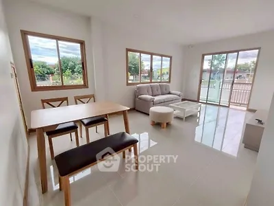 Spacious living room with modern furniture and large windows offering natural light.