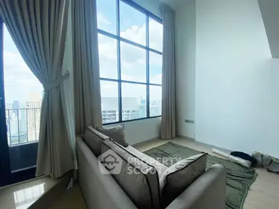 Spacious living room with floor-to-ceiling windows offering stunning city views.