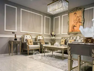 Luxurious living room with elegant furniture and classic decor, featuring a chandelier and framed artwork.