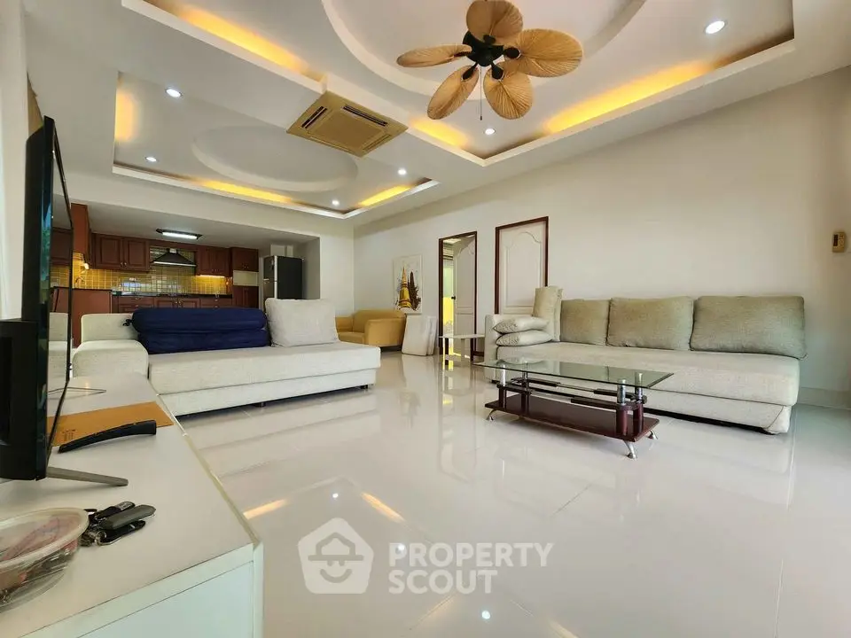 Spacious modern living room with elegant ceiling design and cozy seating area.