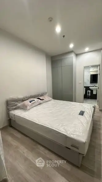 Modern bedroom with sleek design and ensuite bathroom in a stylish apartment.