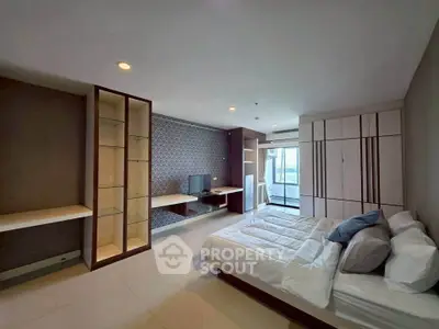 Spacious modern bedroom with stylish decor and large windows offering natural light.