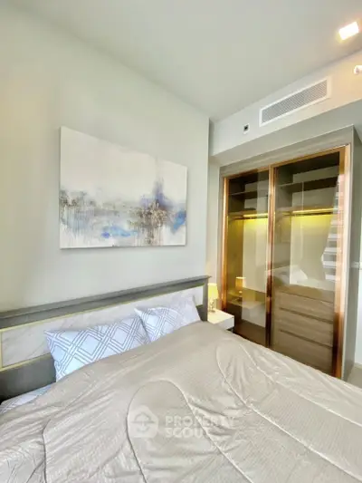 Modern bedroom with stylish decor and built-in wardrobe in a luxury apartment.