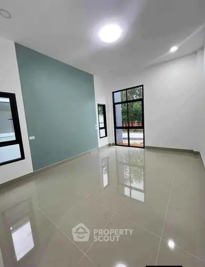 Spacious modern living room with large windows and glossy tiled floor
