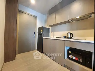 Modern kitchen with sleek cabinetry, compact appliances, and stylish design in a contemporary apartment.