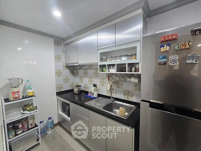 Modern kitchen with sleek cabinets and stainless steel appliances, featuring a compact yet efficient layout.