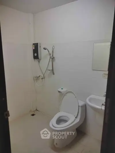 Minimalist bathroom with shower and toilet in a modern apartment.