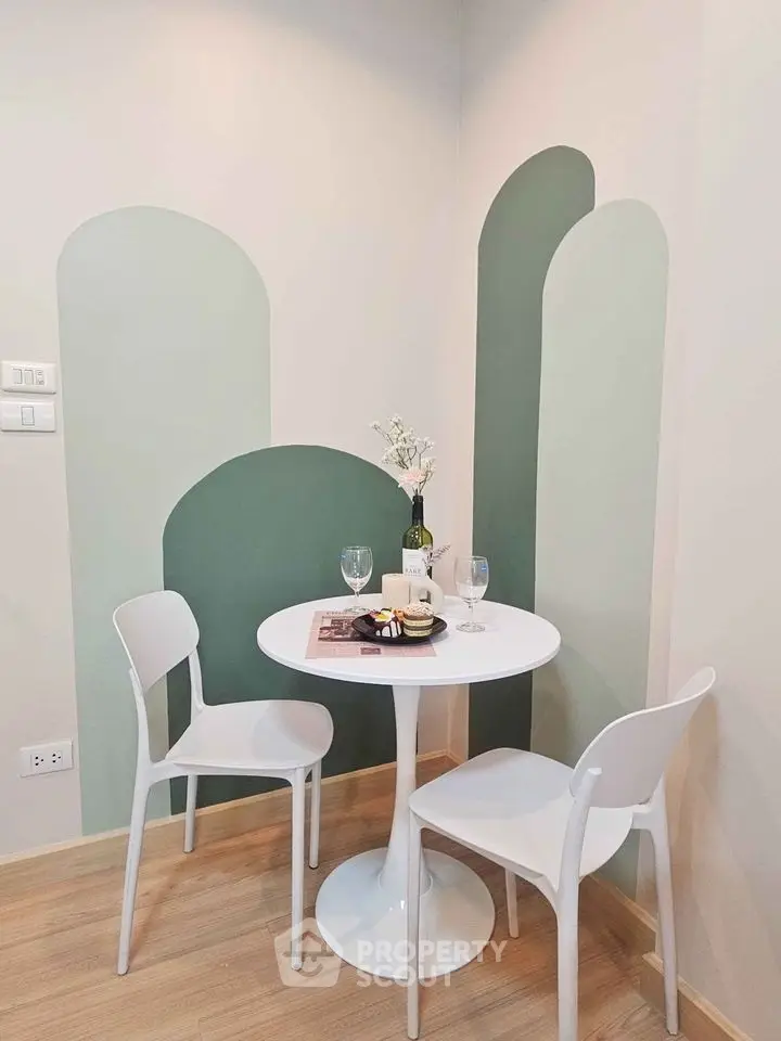 Chic dining nook with modern white table and chairs, accented by stylish wall art, perfect for cozy meals.