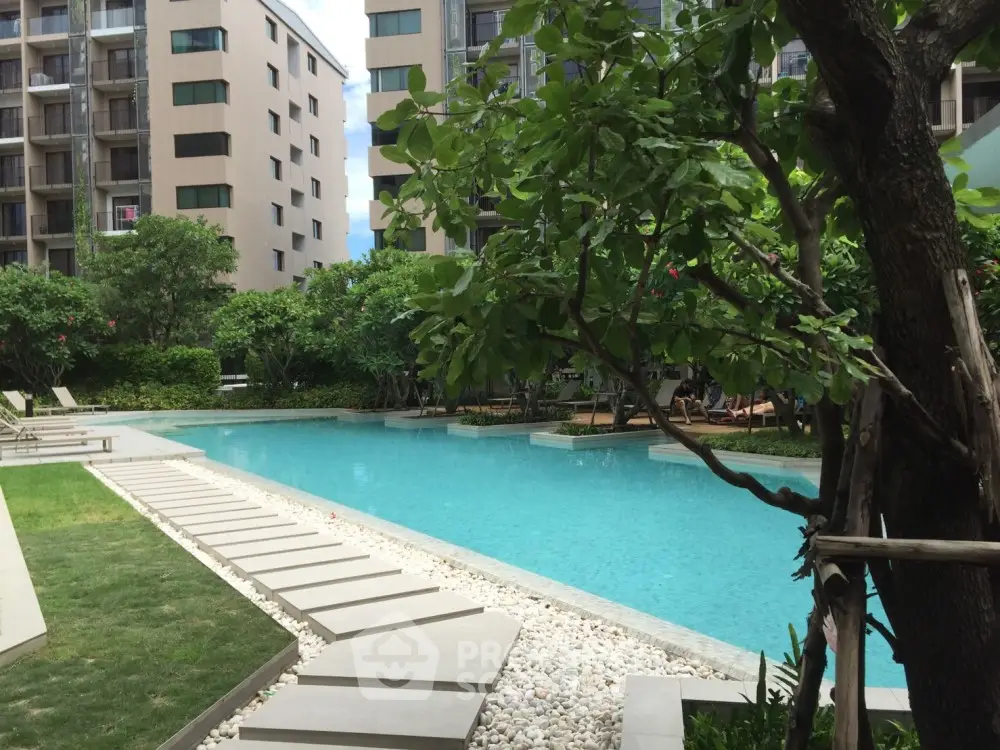 Luxurious condominium pool area with lush greenery and modern design