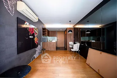 Modern open-layout living room with stylish kitchen and mirrored wall
