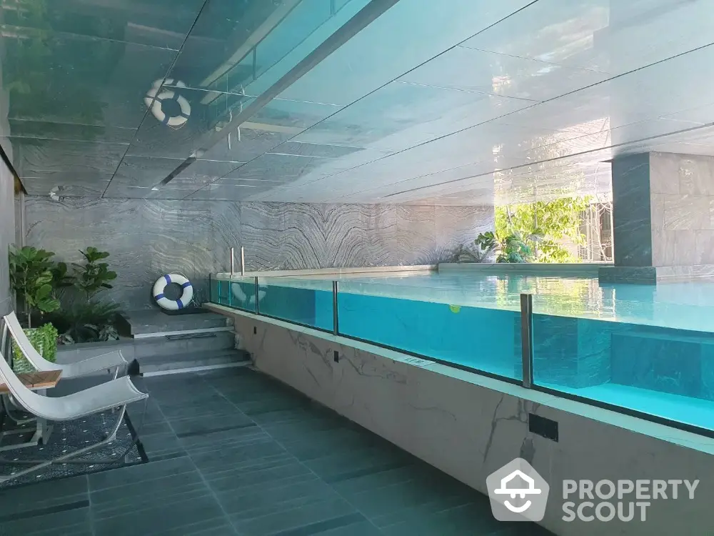 Luxurious indoor pool with modern design and glass walls in upscale property