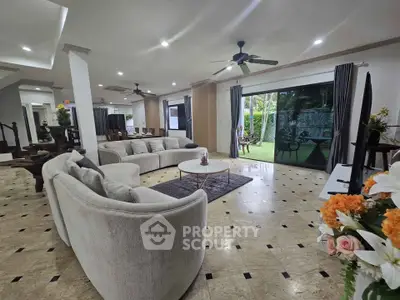 Spacious living room with elegant decor and garden view, perfect for family gatherings.