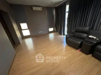Spacious living room with wooden flooring and modern recliner sofa, perfect for relaxation.