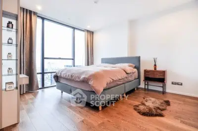 Modern bedroom with large window and stylish decor in a luxury apartment.