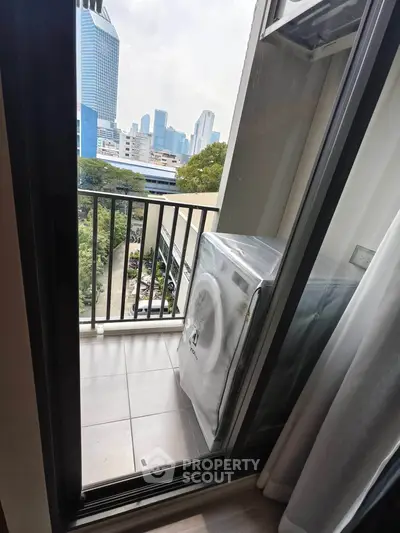 Modern apartment balcony with city view and washing machine setup.