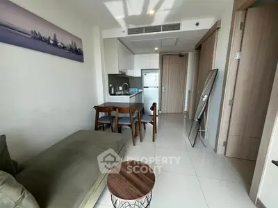 Modern apartment living room with open kitchen and stylish furniture.