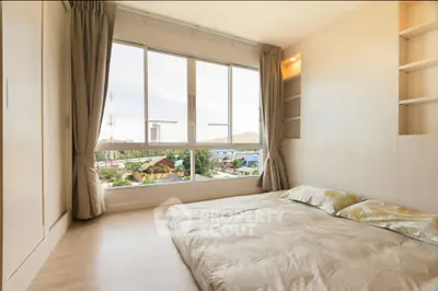 Cozy minimalist bedroom with large window offering scenic city view, perfect for relaxation and comfort.