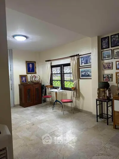 Cozy living room with marble flooring and wall art, perfect for relaxation.