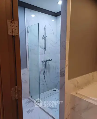 Elegant bathroom with glass shower and marble tiles, perfect for modern living.