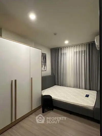 Modern bedroom with minimalist design, featuring a comfortable bed and sleek wardrobe.
