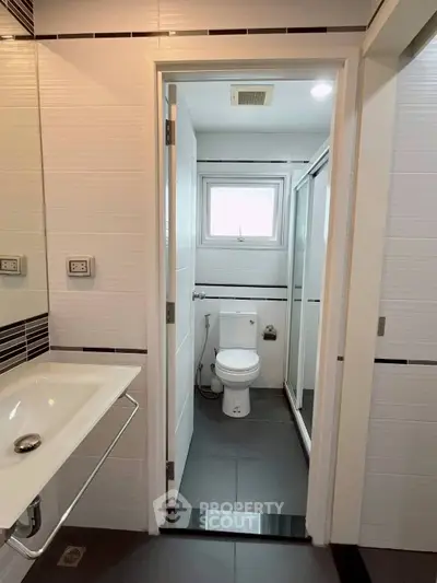 Modern bathroom with sleek design, featuring a spacious shower and contemporary fixtures.