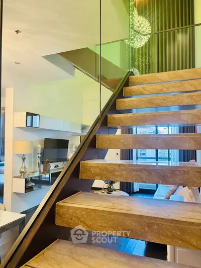 Luxurious modern staircase with glass railing in elegant living room