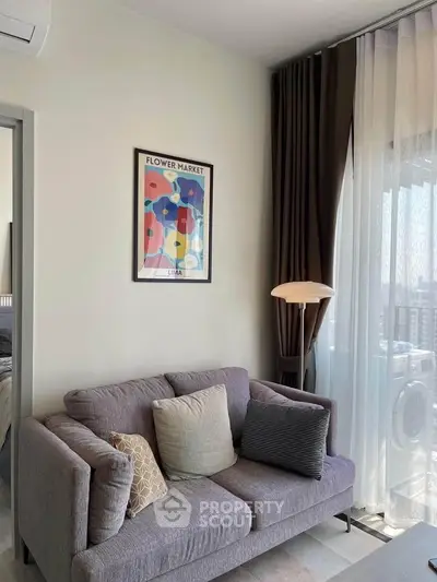 Modern living room with stylish sofa and floor lamp, featuring a vibrant flower market artwork.