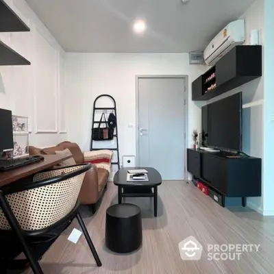 Modern living room with sleek furniture and wall-mounted TV in stylish apartment.