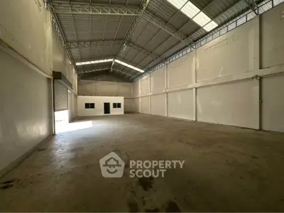 Spacious industrial warehouse with high ceilings and ample natural light.