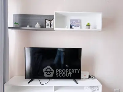 Modern living room with sleek TV setup and stylish wall shelves.