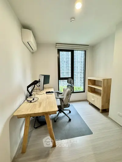 Modern study room with desk, chair, and large window view in urban apartment