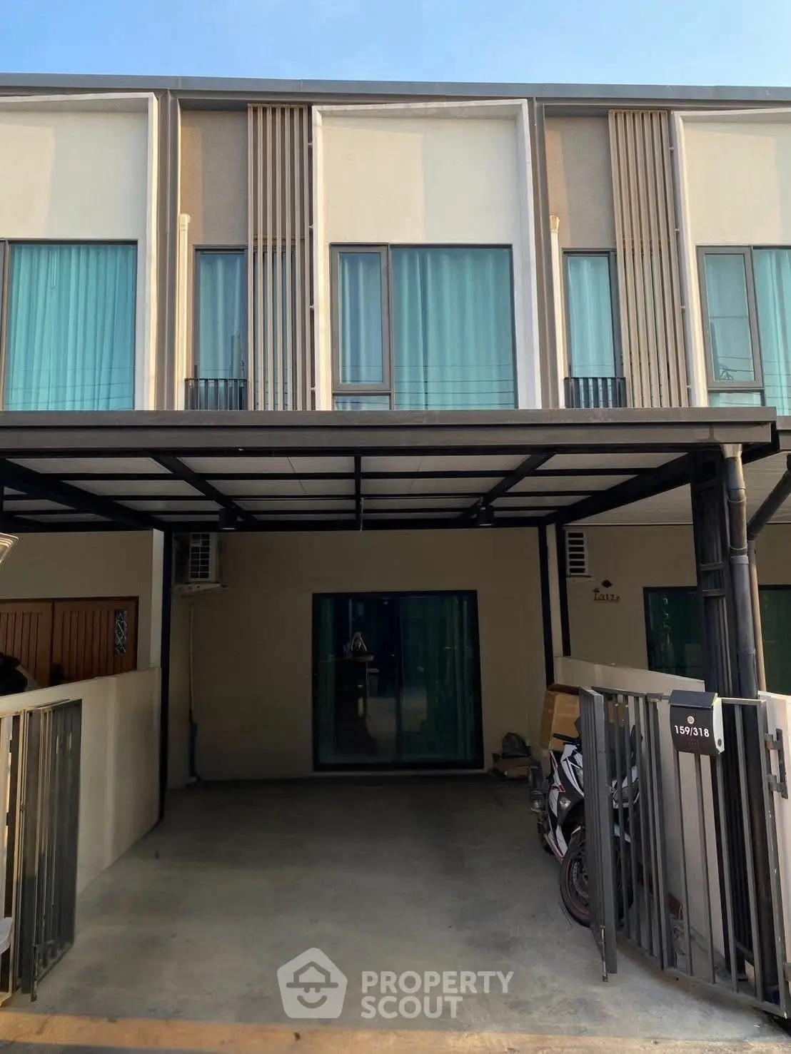 Modern townhouse exterior with gated parking and sleek design