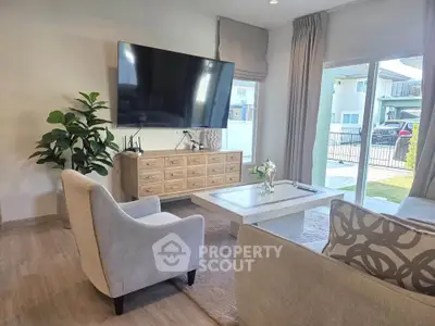 Modern living room with large TV, elegant furniture, and garden view, perfect for stylish family living.