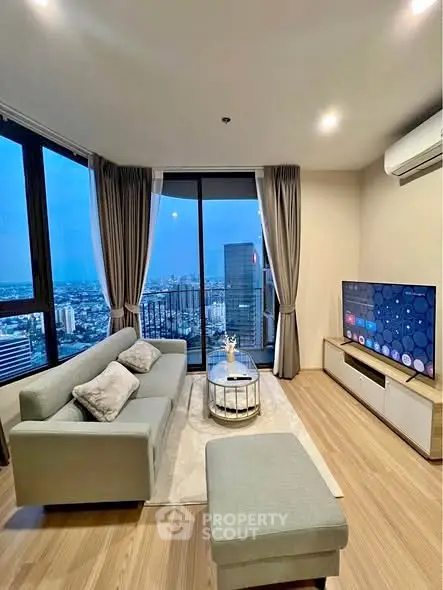 Modern living room with stunning city view, featuring sleek furniture and large windows for natural light.