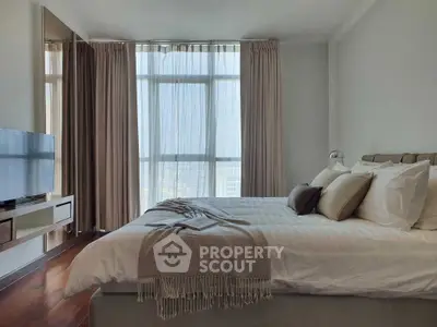 Luxurious bedroom with large windows and elegant decor in a modern apartment.