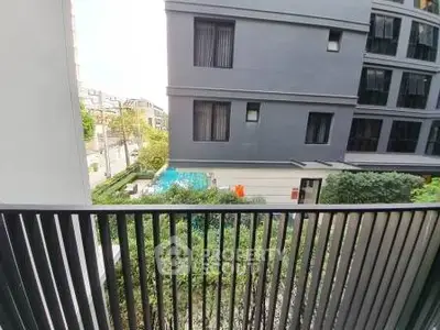 Modern apartment balcony with city view and lush greenery