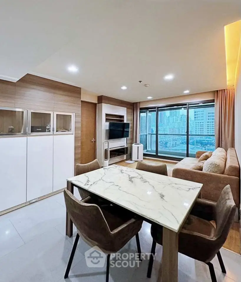 Modern living room with city view, stylish furniture, and elegant dining area in a high-rise apartment.