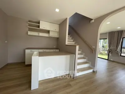 Modern open-plan living area with staircase and natural light
