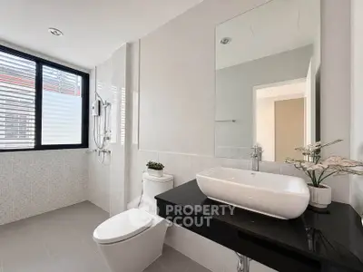 Modern bathroom with sleek fixtures and large window for natural light.