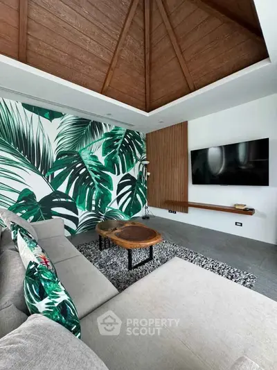 Stylish living room with tropical decor and wooden ceiling, featuring a cozy sofa and modern TV setup.