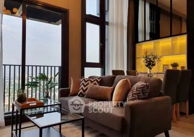 Luxurious living room with modern decor and stunning city view from balcony.