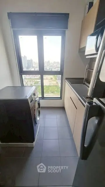 Modern kitchen with washing machine and city view from large window