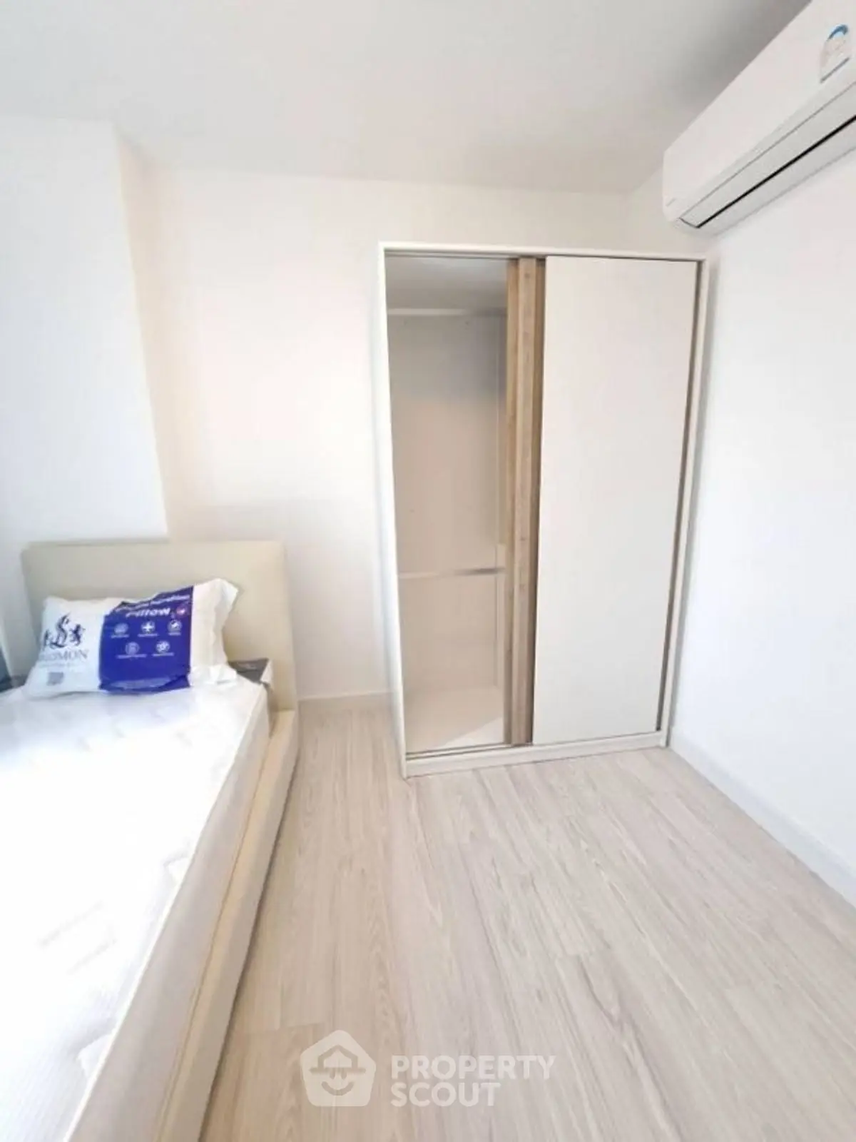 Modern minimalist bedroom with sleek wardrobe and air conditioning