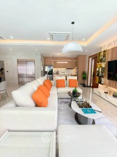 Luxurious modern living room with elegant decor and open kitchen layout, featuring plush seating and stylish lighting.